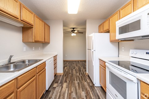 A kitchen with wooden cabinets and white appliances.