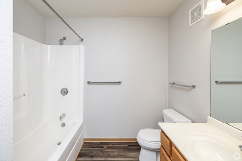 A white bathroom with a toilet, sink, and bathtub.
