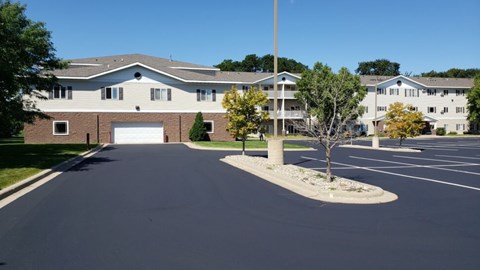 A parking lot in front of a building with a clear blue sky.