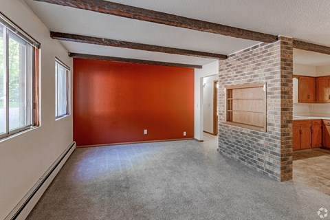 A room with a red wall and a fireplace.