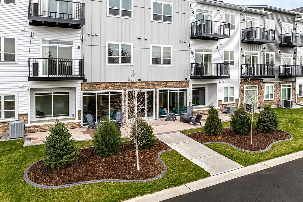 an exterior view of an apartment building with lawns and trees
