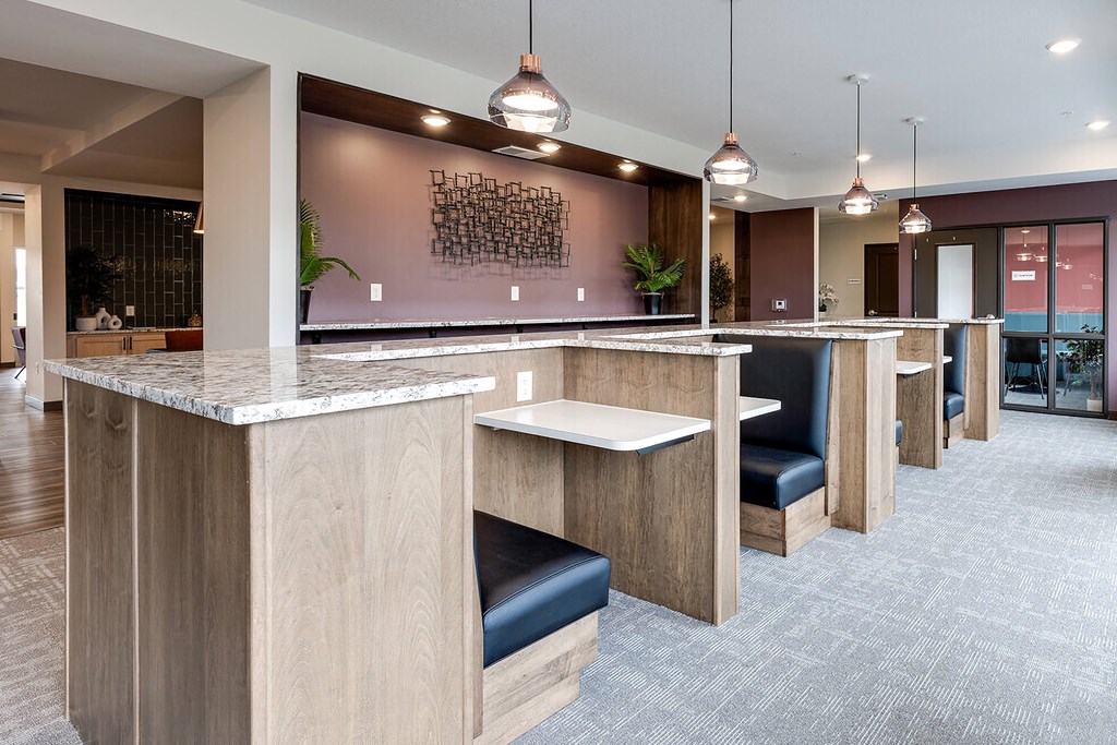 individual work areas in lobby of a building with black leather chairs