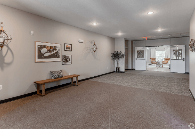 A room with a bench and pictures on the wall.