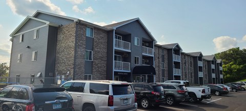 an apartment building with cars parked in front of it