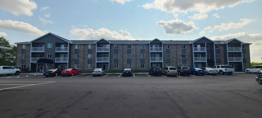 an empty parking lot in front of an apartment building