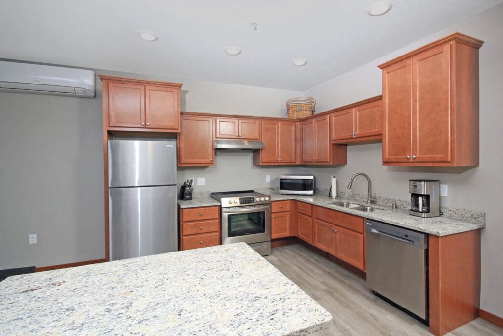 a kitchen with wooden cabinets and stainless steel appliances