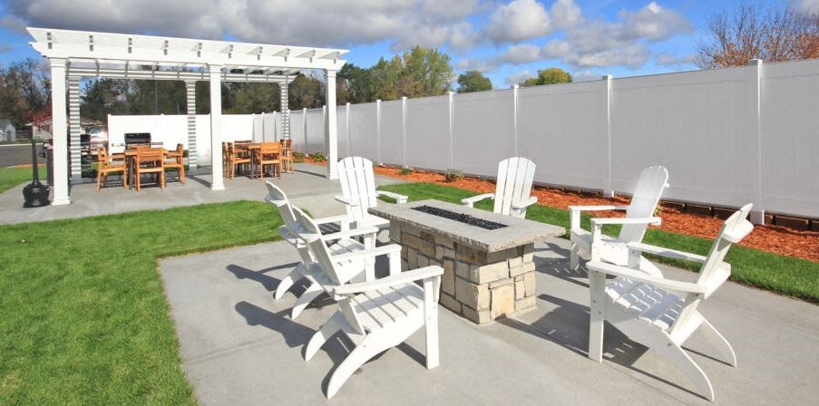 a patio with chairs and tables and a fence