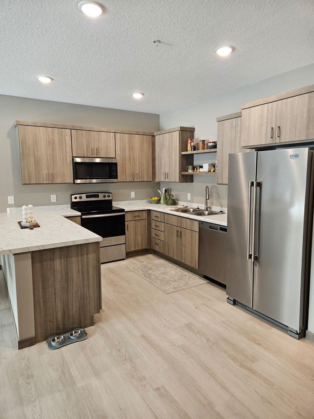 A modern kitchen with wooden cabinets and stainless steel appliances.