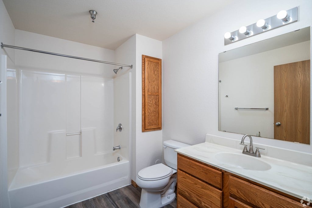 A white bathroom with a toilet, sink, and bathtub.