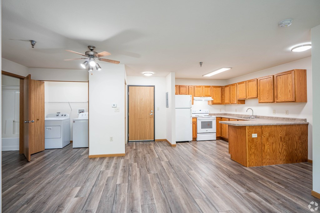 A kitchen with wooden floors and white appliances.