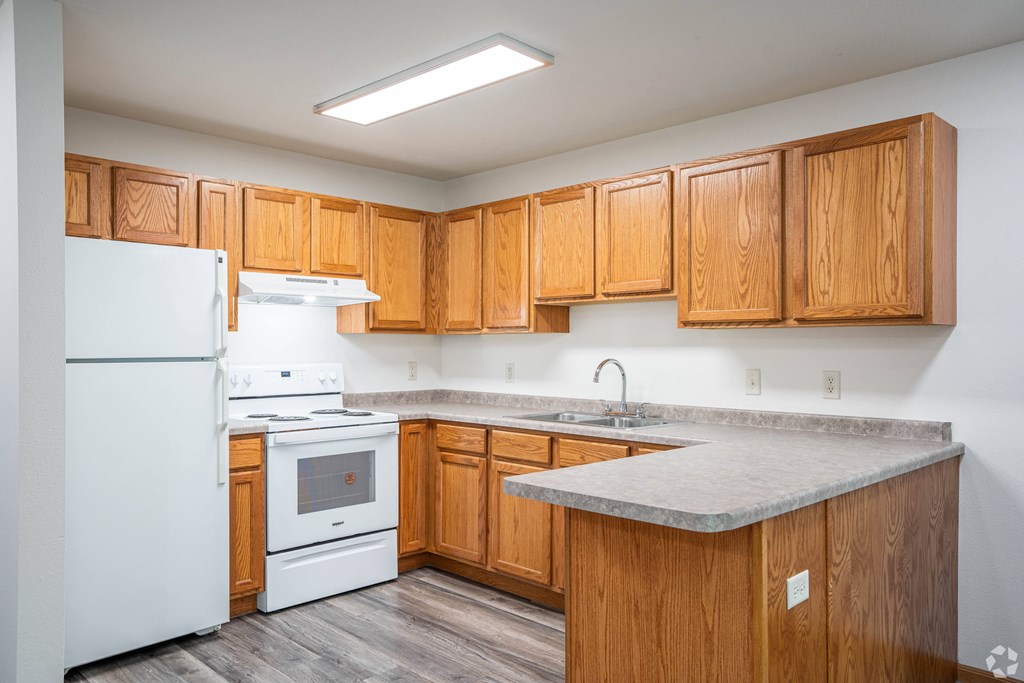 A kitchen with wooden cabinets and a white refrigerator.
