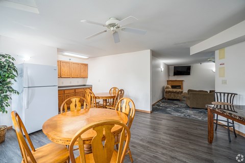 A dining room with a wooden table and chairs.