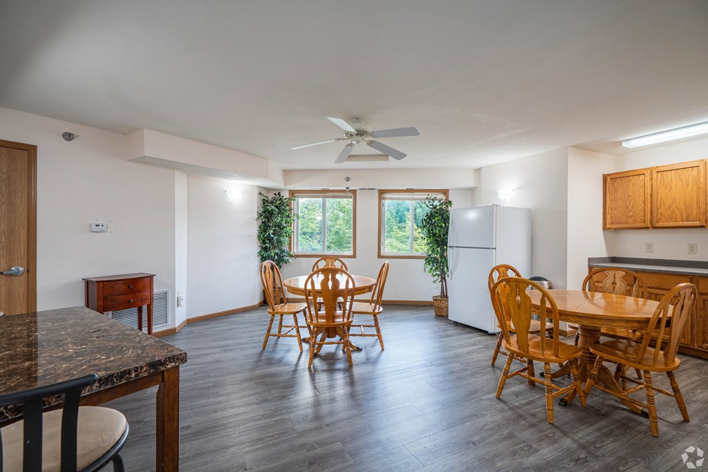 A kitchen with a table and chairs in front of a window.