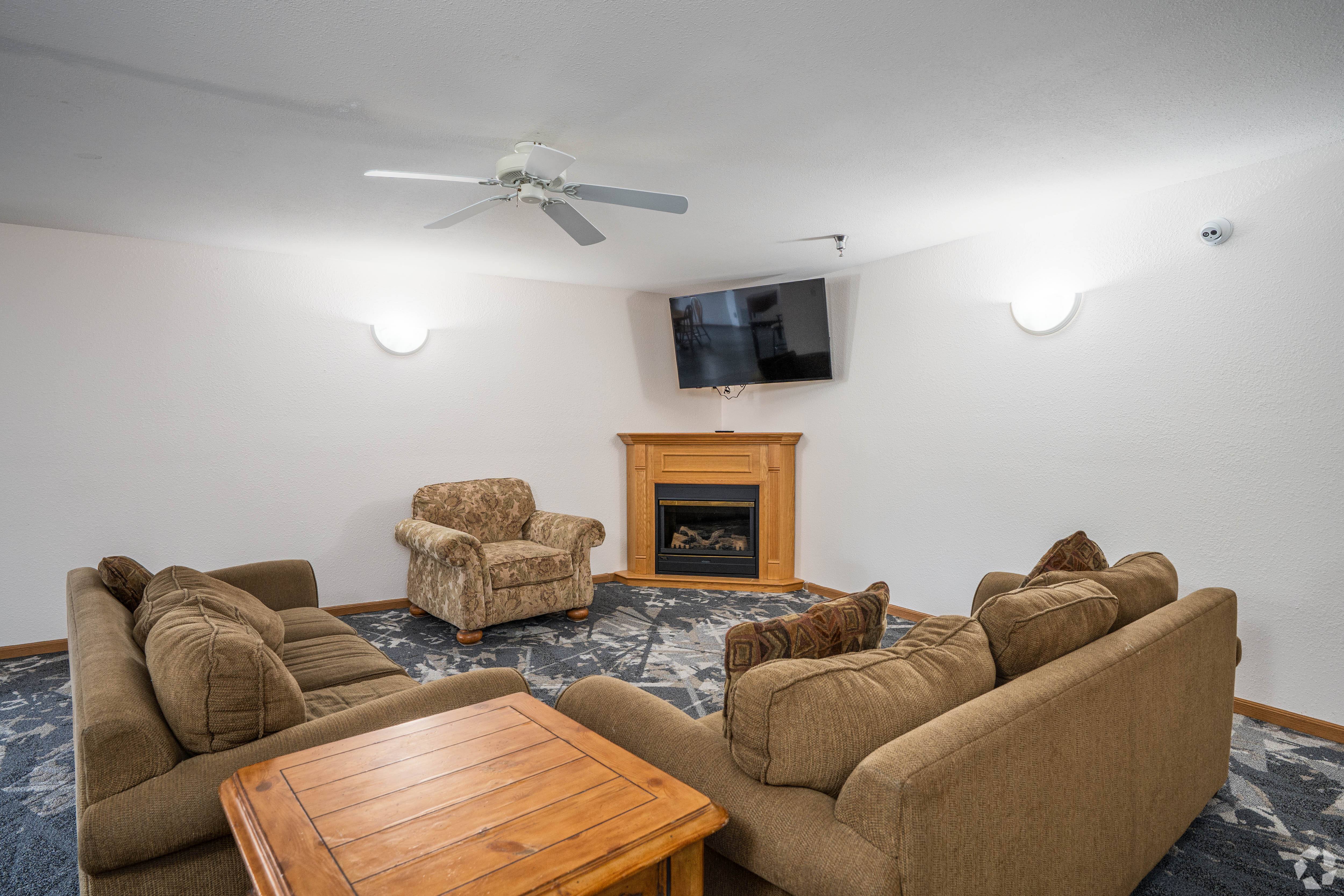 A living room with a fireplace and a television mounted on the wall.