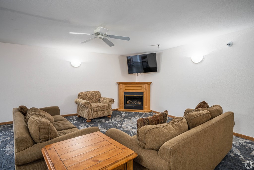A living room with a fireplace and a television mounted on the wall.