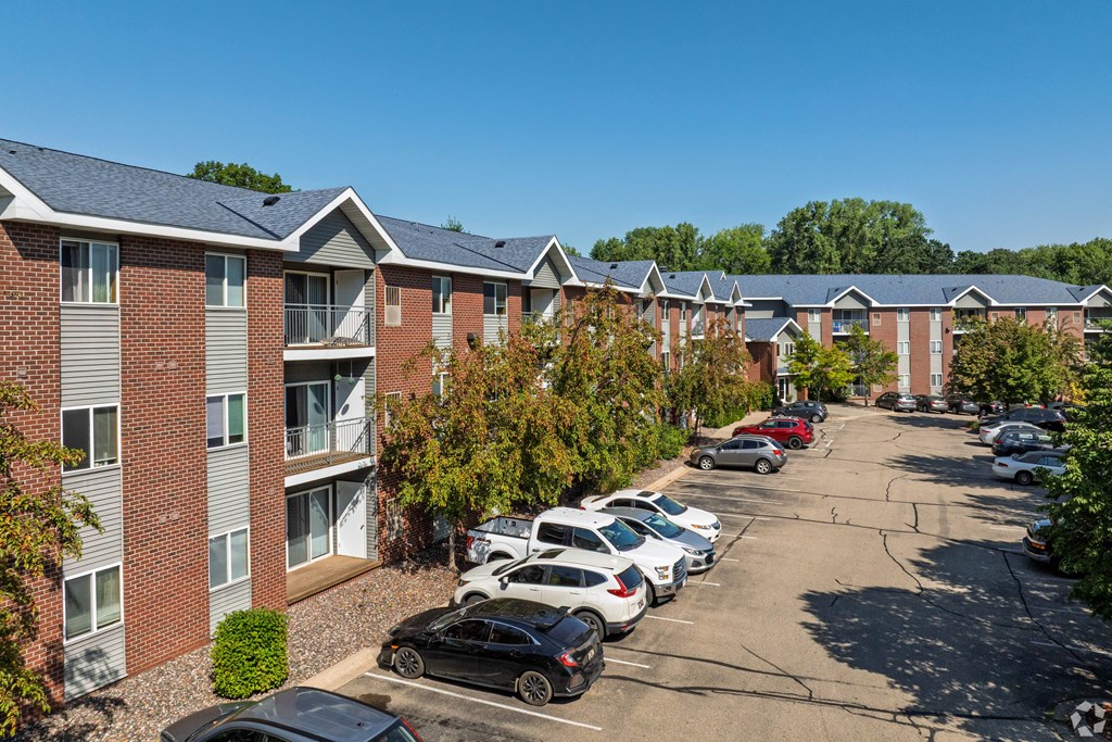 A parking lot with cars and apartment buildings in the background.
