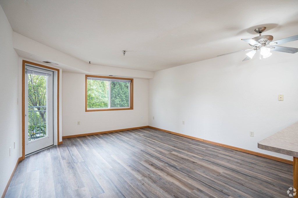 A room with a ceiling fan and a sliding glass door.