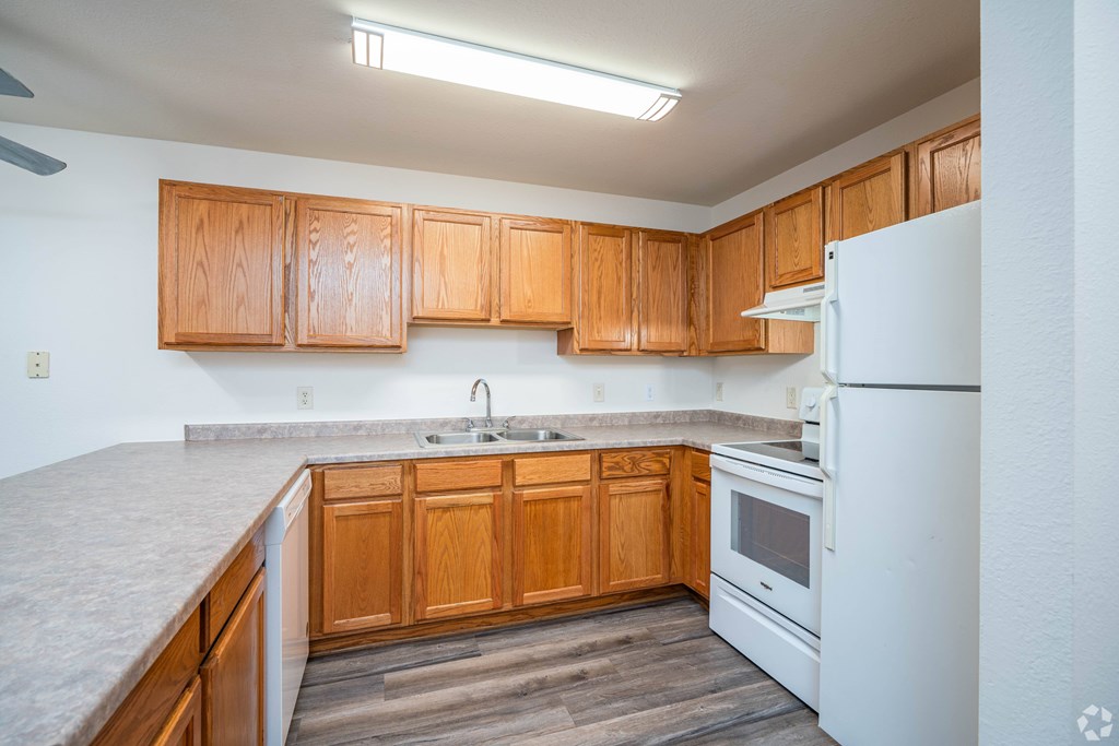 A kitchen with wooden cabinets and a white refrigerator.