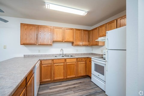 A kitchen with wooden cabinets and a white refrigerator.