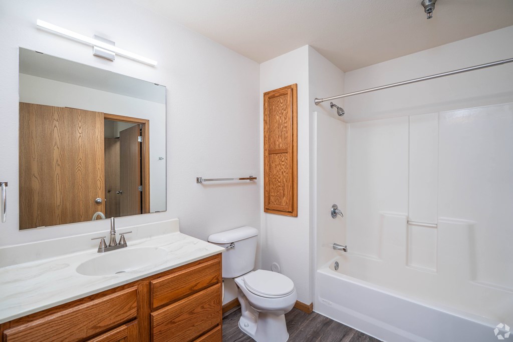 A white bathroom with a toilet, sink, and bathtub.