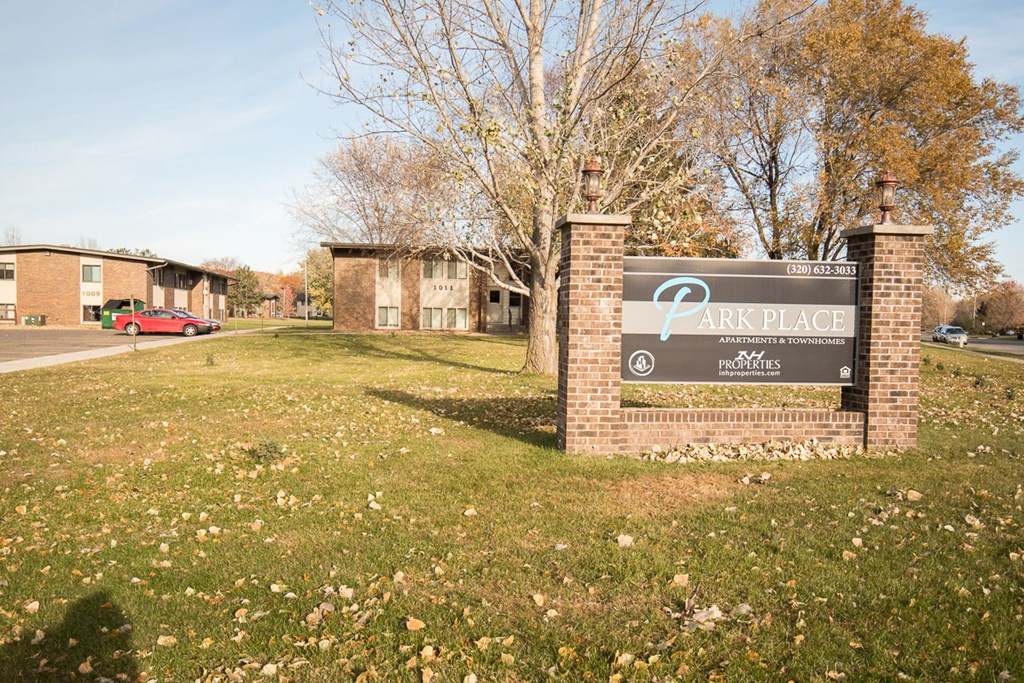 A sign for Park Place apartments is in front of some buildings.