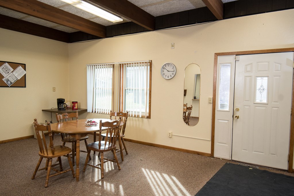 A dining room with a table and chairs.