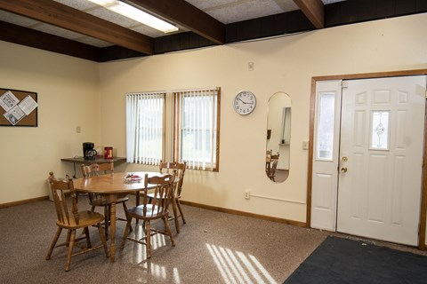 A dining room with a table and chairs.