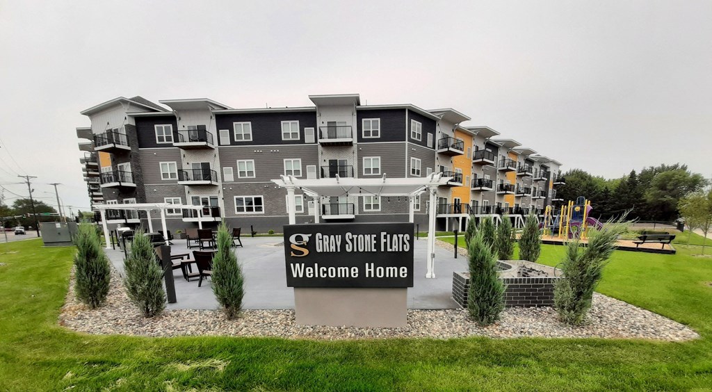 an apartment building with a welcome sign in front of it