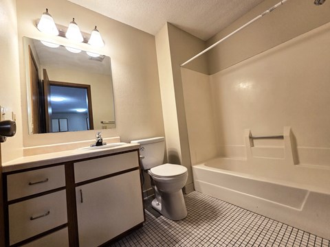 A bathroom with a toilet, sink, and bathtub.