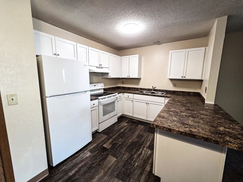 A kitchen with white appliances and cabinets.