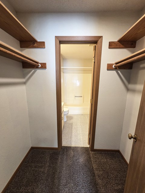 A bathroom with a toilet and sink is visible through an open door.