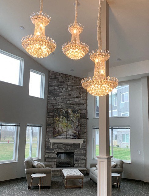 a living room with a fireplace and three chandeliers