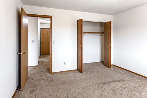 A room with two doors and a carpeted floor.