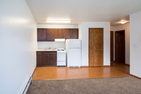 A kitchen with white appliances and wooden cabinets.