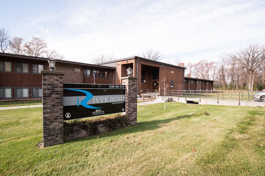 A sign for River Bend is in front of a building.