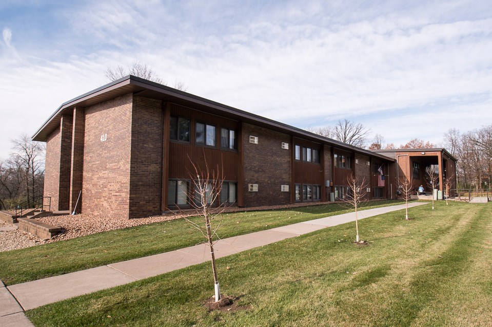 A modern brick building with a grassy area in front.