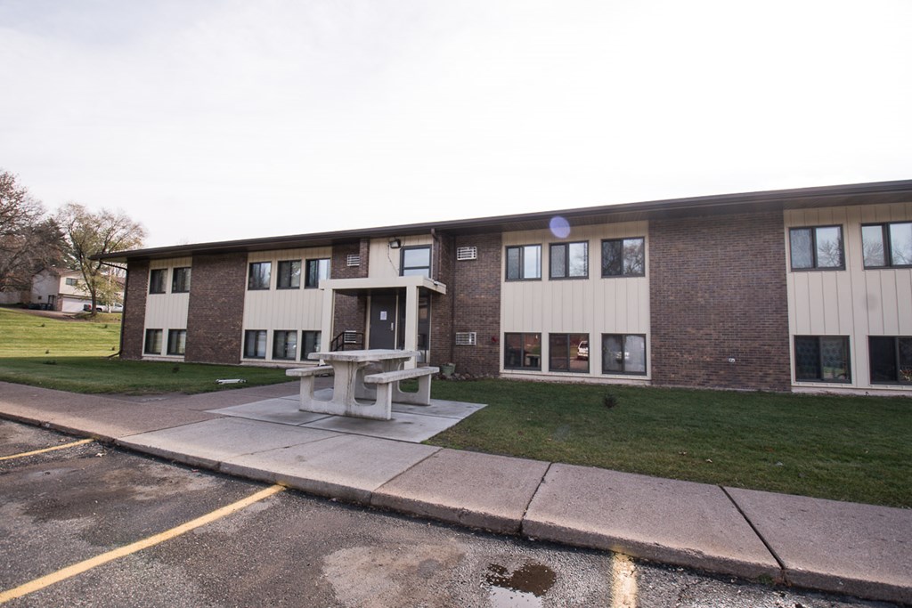 A building with a white picnic table in front of it.