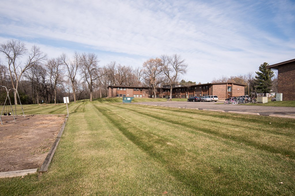 A grassy field with a building in the background.