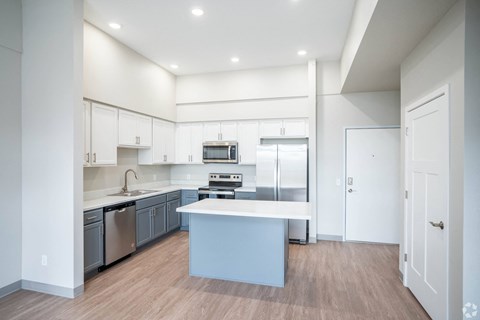 a large kitchen with white cabinets and stainless steel appliances