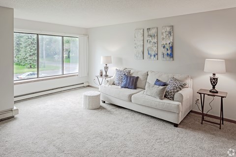 A living room with a white couch and two lamps.