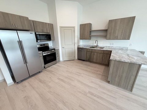 A kitchen with a refrigerator, oven, and microwave.