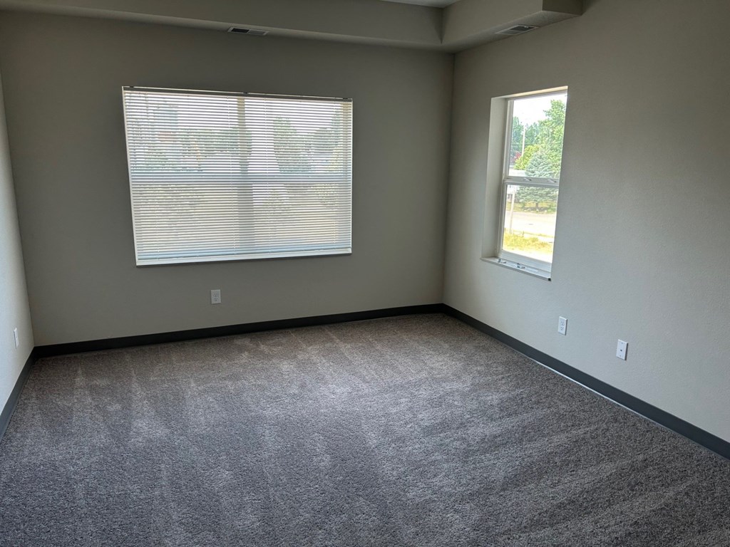 an empty room with carpet and a window