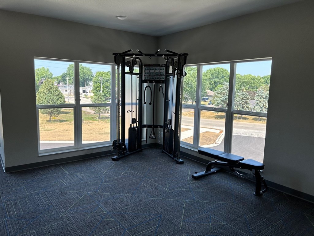 a gym with large windows in the corner of a room