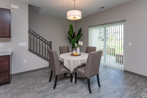 A dining room with a table set for four.