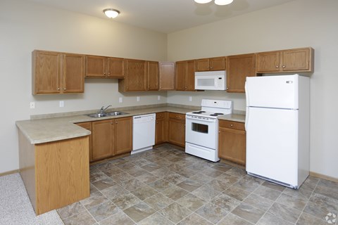 A kitchen with white appliances and wooden cabinets.