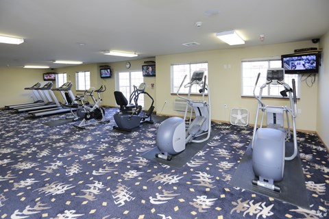 A gym with exercise equipment and a television.