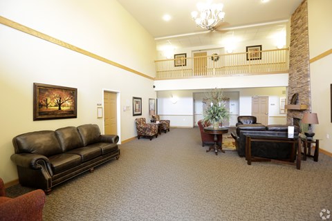 A living room with a couch, chair, and a painting on the wall.