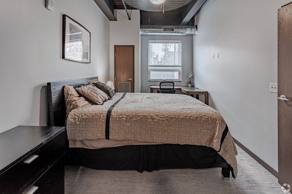 a bedroom with a bed and a dresser and a window