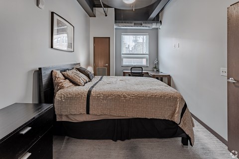 a bedroom with a bed and a dresser and a window