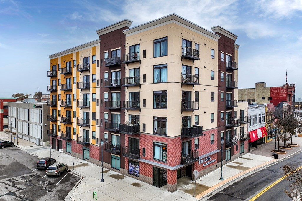 a city street with an apartment building with different colors and balconies